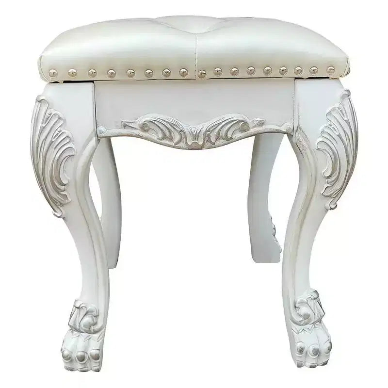 Un élégant fauteuil de salon au fini blanc, dégageant un esprit romantique ; des oreilles couleur champagne et des clous décoratifs.