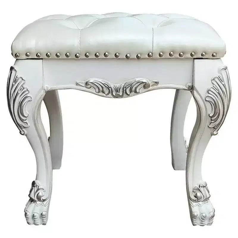 Un élégant fauteuil de salon au fini blanc, dégageant un esprit romantique ; des oreilles couleur champagne et des clous décoratifs.