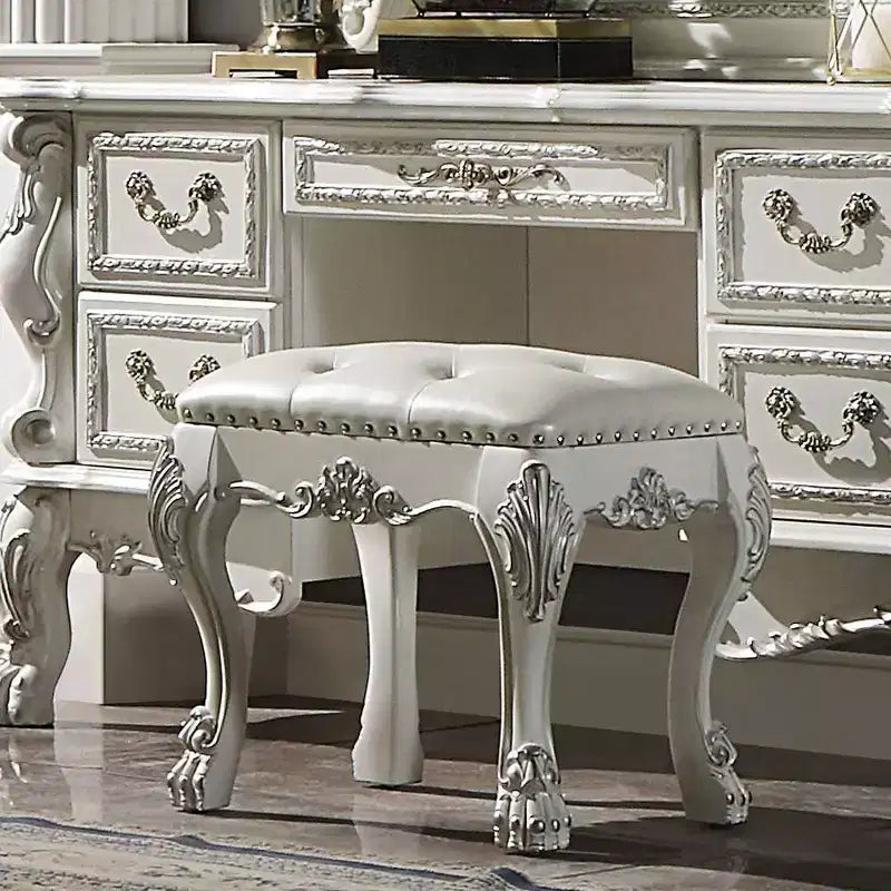 Un élégant fauteuil de salon au fini blanc, dégageant un esprit romantique ; des oreilles couleur champagne et des clous décoratifs.